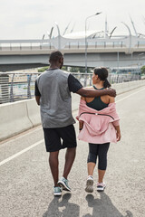 Rear view of young couple talking to each other during their walk in the city