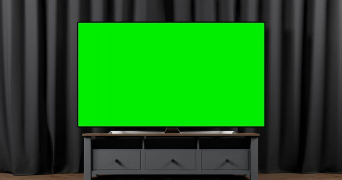 The camera slide to the green screen of a modern TV set on the cupboard