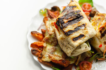 Grilled tortilla wrap with southern style chicken breast with sweet potato fries served on the mix salad