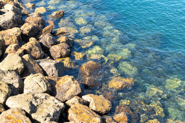 Fototapeta na wymiar The stone coast of the sea with clear water