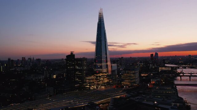 Amazing evening elevated footage of modern skyscraper on River Thames south bank. Tall The Shard after sunset. London, UK