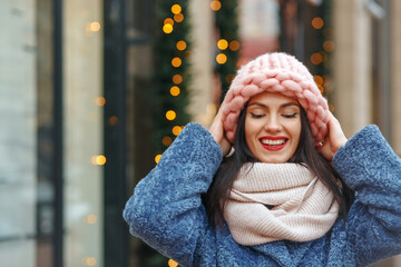 Happy lady in coat walking at the city