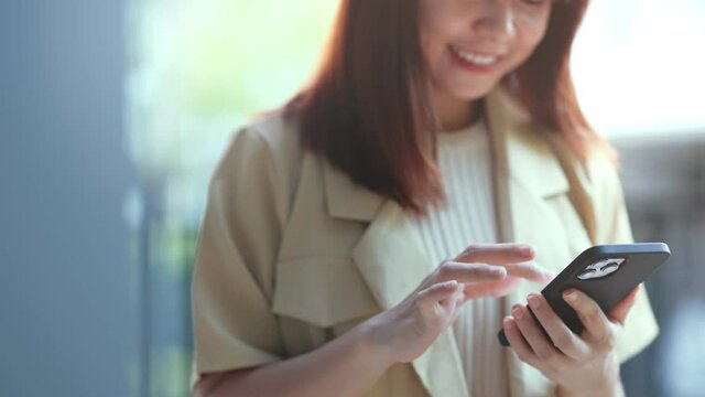 Close up young woman holding smartphone in hands, scrolling personal page in social network, looking at photos, reading news in media, web surfing information.