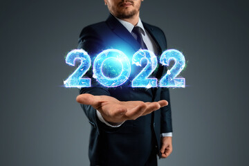 Blue hologram number 2022 on the background of a businessman. Happy New Year. Modern design,...