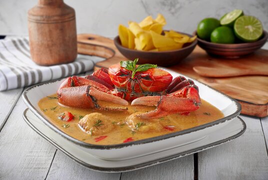 Cangrejo tradicional ecuatoriano con sopa de man&iacute;, canguil, tabla de picar, pl&aacute;tano maduro y pan