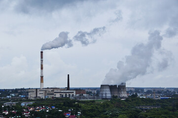 City panorama. View of the pipes of the thermal power plant. Thunderclouds over the city, before...