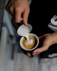 barista pouring cream into coffee - 457905362