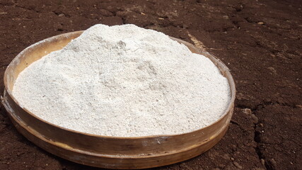 Fototapeta na wymiar cassava flour in a bamboo basket on dry ground.Manihot esculenta, commonly called cassava, manioc,or yuca