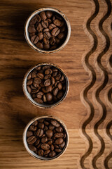 Obraz na płótnie Canvas coffee beans in cups on a wooden background with a pattern. High quality photo