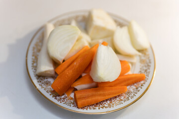 Chopped onions, carrots and parsley on a decorated plate.