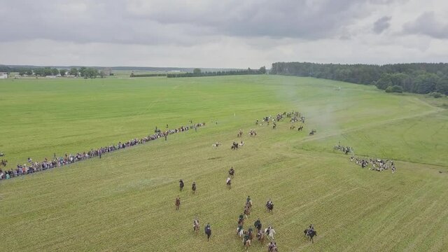 Aerial wide view of reconstruction of the battle of 1812. Soldiers fire cannons and rifles, cavalry gallops. Explosions and shots on the battlefield. Historical concept.