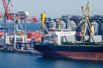 Port cargo crane loads a container onto a cargo ship in a seaport