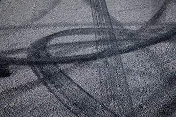 Wheel tire tracks on grey asphalt,  black tire tracks skid on asphalt road, curves and lines, abstract street background