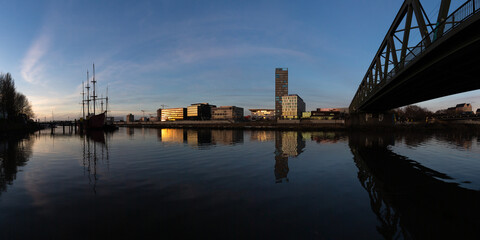 panorama of the Überseestadt, Bremen, Germany, a commercial district with modern architecture at the river Weser at sunset