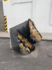 Old damaged sofa dropped in street manhole