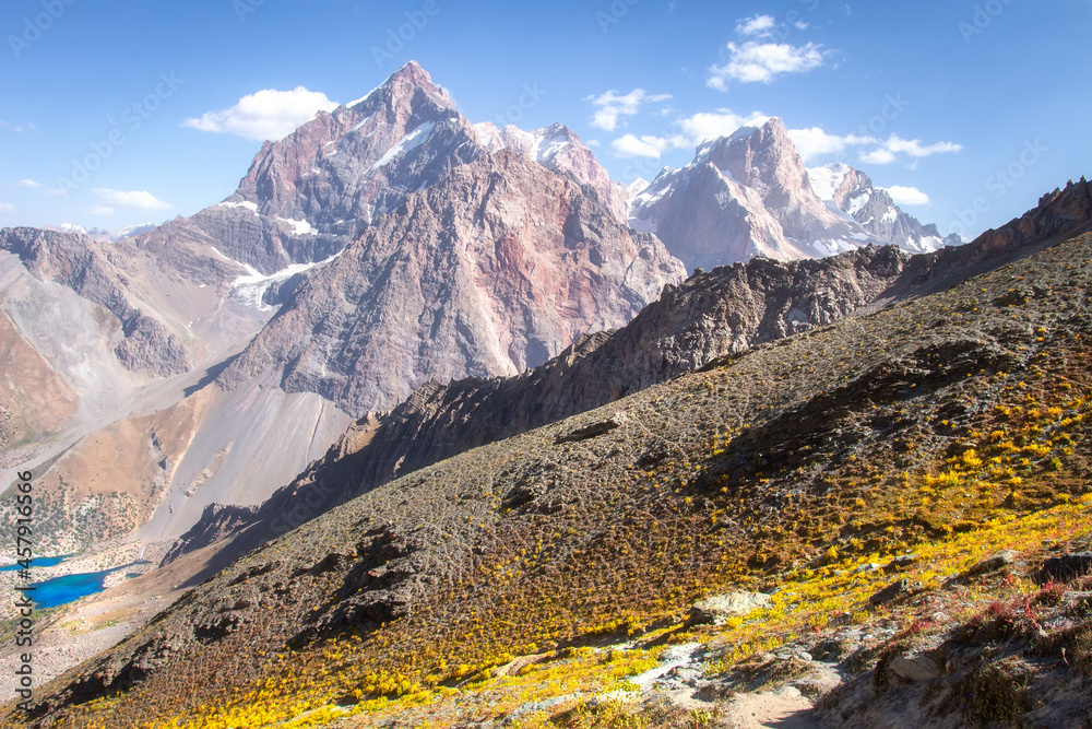 Wall mural beautiful scenic view on snow peaks in the distance. hiking on moutains places. blue clean sky above