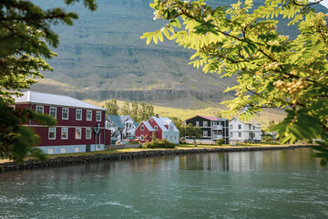 Houses next to a bay of beautiful icelandic village of seydisfjordur, on a summer day. Colorful icelandic houses.