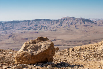 Large rock in the foreground against the background of Ramon crater on a summer morning. Israel. 