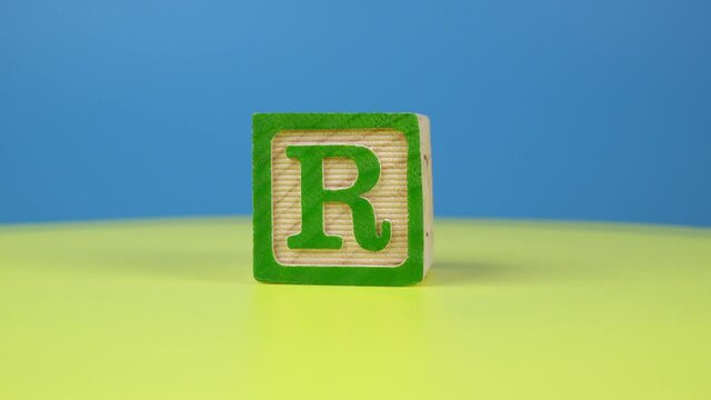 Close up shot letter "R" alphabet wooden block on surface