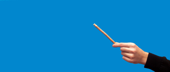 Guy hold miswak on blue background. Teeth cleaning. Sunnah teeth brushing. Sivak. Banner