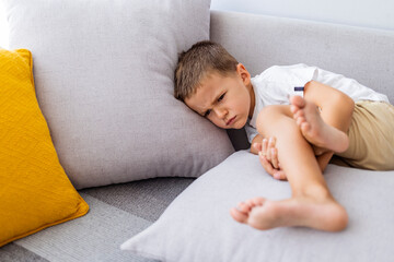 Cute angry boy. Morning home. Naughty little boy. Angry little boy frowned while sitting in bed and...