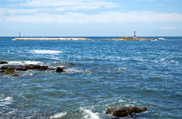 Waves crashing the rocks at Porec beach, Istria, Croatia. Blue sky and sea horizon 