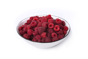 Red raspberry berry in plate on wooden table.