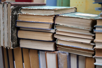 Fototapeta premium Stacks of scattered new and old books are on top of each other