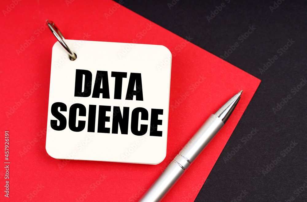 Aufkleber on a black and red background lies a pen and a notebook with the inscription - data science
