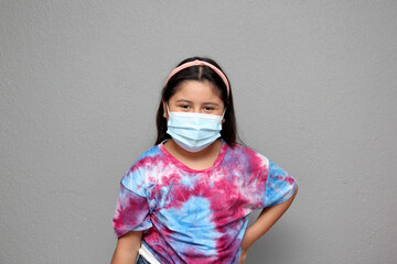 10-year-old girl very happy shows the mask that she uses in the new normal for the Covid-19 pandemic to protect herself from the Coronavirus
