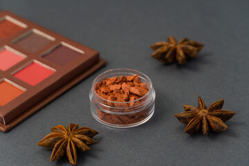 Artistic photography of cosmetics. Eye shadow and face powder on a grey background