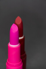 Lipstick luxury photo. Most classic lipsticks colours dark red, bright pink and vivid red on a dark grey background  