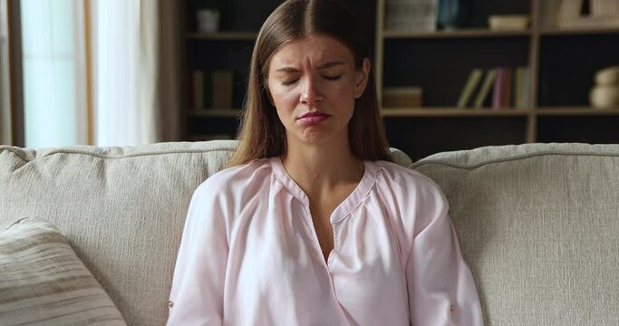 Negative answer. Disappointed gen z female sit on sofa browse chat app on phone feel sad annoyed finding no messages from boyfriend. Upset young lady check mail client read bank refusal in giving loan