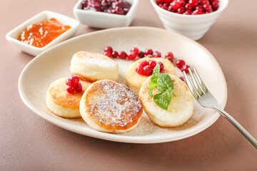 Plate with tasty cottage cheese pancakes and cranberry on table