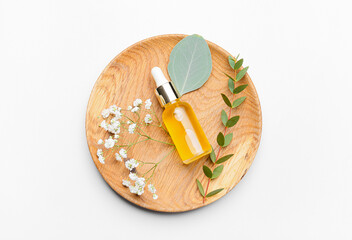 Bottle of healthy essential oil on light background
