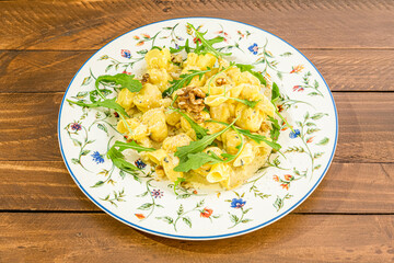 Italian recipe for ravioli stuffed with pear stew, serve with olive oil, California nuts and arugula leaves.
