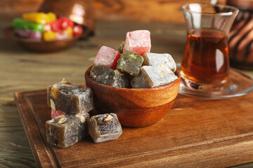 Bowl with sweet Turkish delight on wooden background