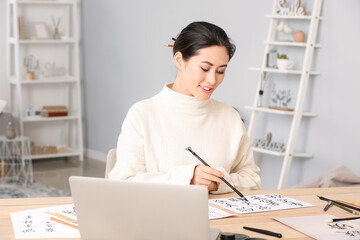 Obraz na płótnie Canvas Female Asian calligraphist working in office