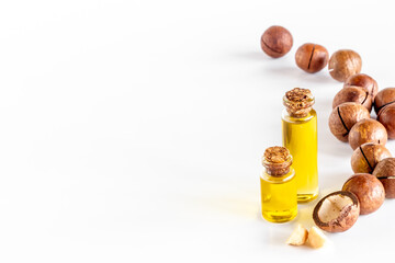 Macadamia nut oil in glass bottle with nuts. Essence extra virgin oil for food or cosmetic