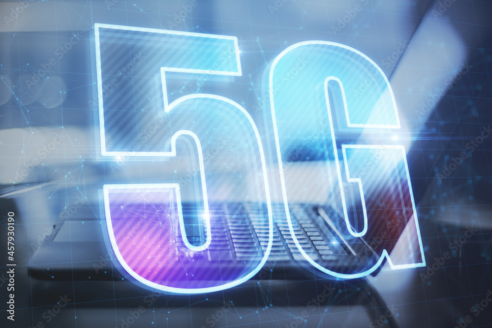 Poster close up of desktop with laptop and abstract glowing 5g hologram on dark blue background. wireless i