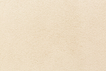 Sample of a texture of beige plaster. Wall finished with a decorative cement stucco. Example of exterior building decoration. Clean uniform grainy background. Banner. Wallpaper. Copy space. Pattern