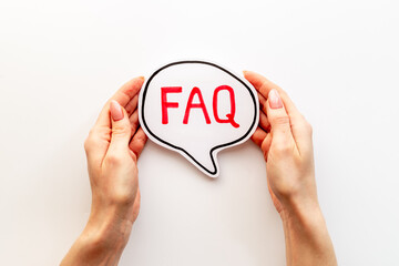 Hands with faq word on paper bubble. Frequently asked questions concept