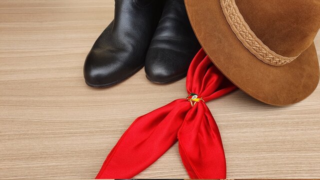 Boot, hat and red scarf on the table. Typical accessories from the tradition of the people of Rio Grande do Sul. Rio Grande do Sul, Brasil.