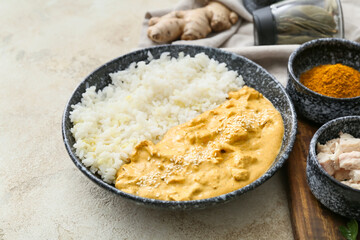 Bowl of tasty chicken curry with rice and ingredients on light background