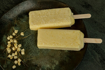 Yellow corn popsicles melting in the plate