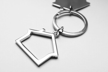 House shape keychain on grey background, closeup