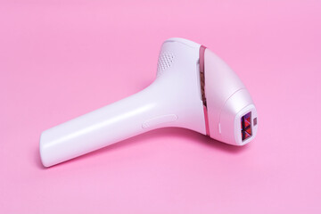 Photoepilator on a pink background. Hair removal tool.
