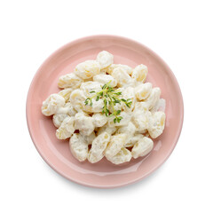 Plate of delicious gnocchi with creamy sauce on white background