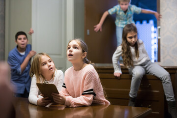 Two focused tween girls trying to solve conundrum to get out of escape room