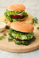 Wooden boards with tasty vegetarian burgers on table